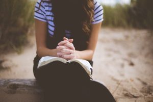 They Gave All-girl with hands clasped in prayer on top of her Bible