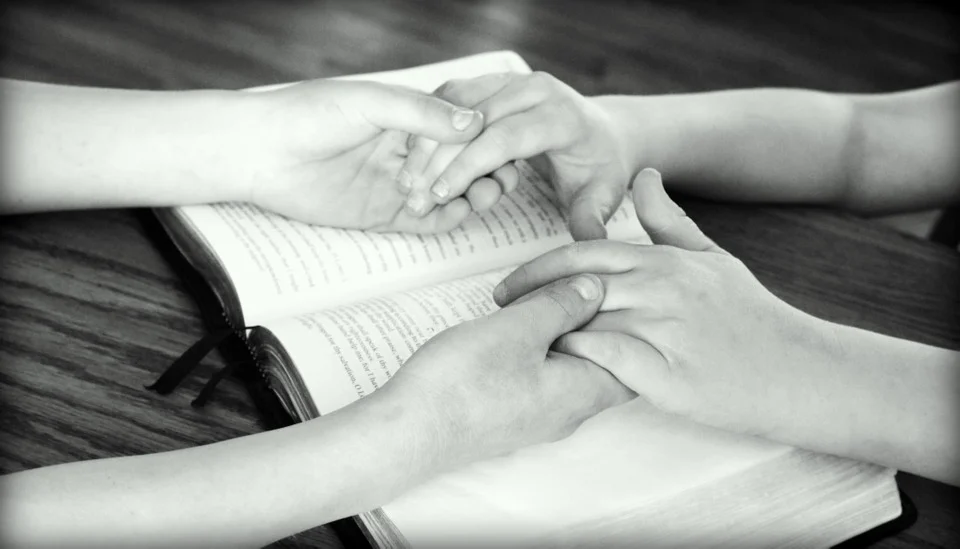 A Prayer for Peace--holding hands above a Bible